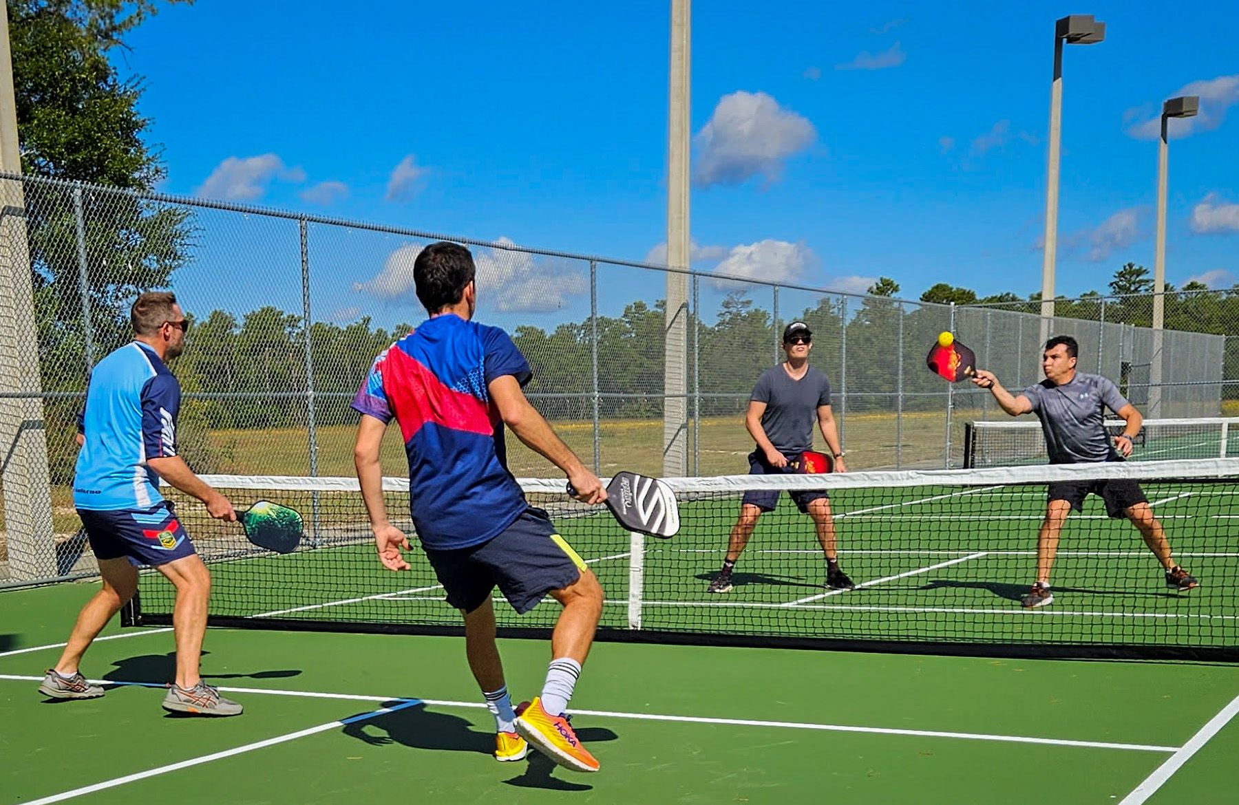 Một nhóm người chơi pickleball vui vẻ trên sân.
